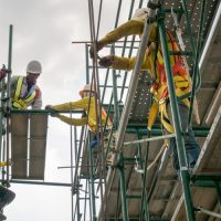Builders climbing on scaffolding at construction site